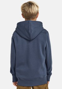 Granatowa bluza z kapturem, z prążkowanymi mankietami i dołem, wykonana z miękkiego materiału, charakteryzująca się prostym, bezszwowym designem bez widocznych logo czy wzorów.