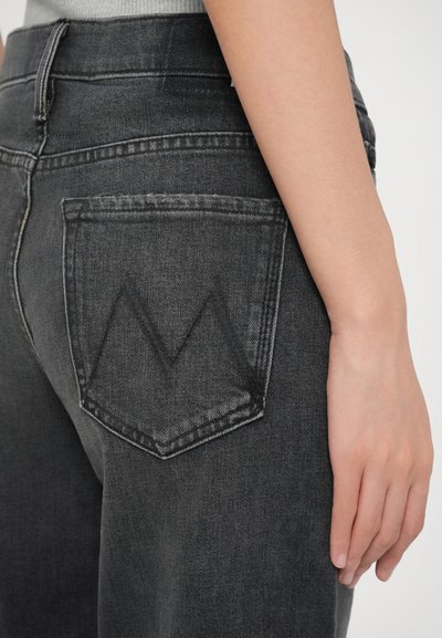 Sive traperice z srednjim pranjem, ki imajo značilno trikotno obliko zadnjega žepa in gladko, rahlo teksturirano površino.