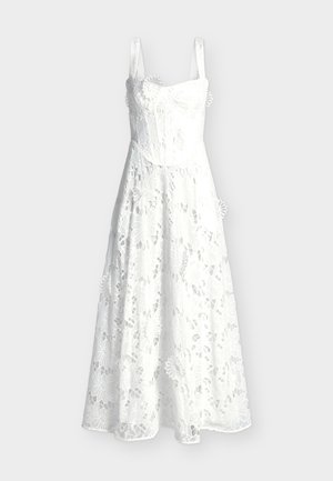 Λευκό μίντι φόρεμα χωρίς μανίκια με λεπτές τιράντες και επικάλυψη από δαντέλα με λουλούδια, διαθέτοντας εφαρμοστή μπούστα και φούστα με φαρδιά γραμμή.