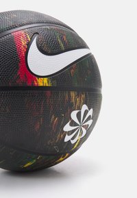 Nike basketball with a textured black surface, featuring a colorful paint splatter design and white logo accents.