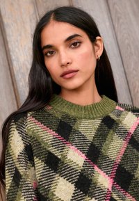 Maglione lavorato a maglia con motivo a quadri verde, nero e panna con accenti rosa, scollo a coste e tessuto morbido.