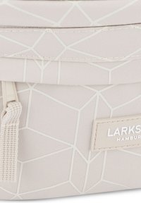 Borsa beige texturizzata con motivo geometrico bianco, dotata di chiusura con zip, nappina decorativa e etichetta embossata con la scritta "LARKS HAMBURG."
