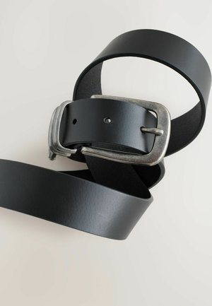 Čierny kožený opasok s textúrovaným povrchom, ktorý má striebornú kovovú sponu. Opasok má prierazy pre nastavenie veľkosti.