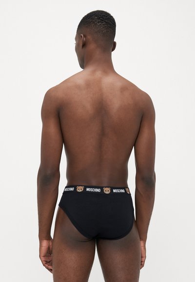 Boxer negru din material moale din bumbac, având un brâu cu logo-uri de urs pe care este imprimat textul "MOSCHINO" în jur. Design minimalist.