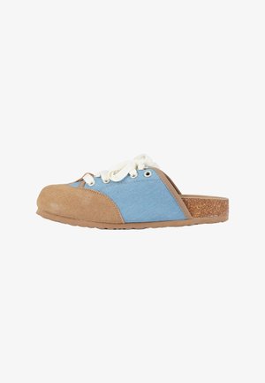 Zoccolo slip-on con tessuto blu e tomaia in suede color cuoio, lacci bianchi e suola con texture sughero, mostrato di profilo su sfondo bianco.