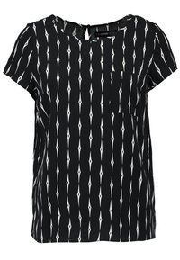 Svart kortärmad topp med ett diamantformat vitt mönster, rund halsringning och liten framficka. Lätt material med en slät textur.