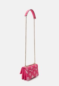 Sac en cuir synthétique rose avec une bandoulière en chaîne, présentant un design plié et des motifs géométriques blancs sur la surface.
