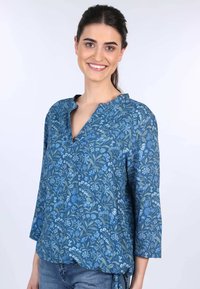 Bluse mit blauem Blumenmuster aus weichem Stoff, mit V-Ausschnitt, dreiviertellangen Ärmeln und einem Bindeband am Saum.