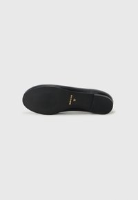 Sola de sapato de couro preto com textura estriada, apresentando as marcações douradas "Feito na Itália" e o tamanho "37". Forma curva com um ligeiro salto.