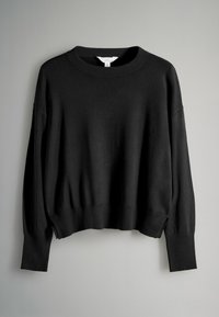 Zwarte, gebreide trui met een ronde hals, verzakte schouders en geribbelde manchetten. Heeft een ontspannen, cropped pasvorm met een zachte textuur.