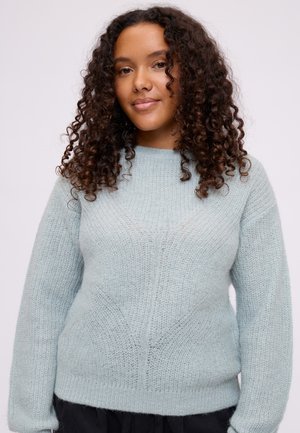 Pull en tricot bleu clair avec une finition texturée, col rond et ourlet côtelé. Il a des manches longues et une coupe décontractée.