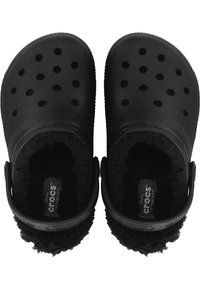 Zapatos tipo zueco negros con un exterior texturizado, múltiples hoyos de ventilación y un suave forro de pelaje en el interior. Incluye correas ajustables para el talón.