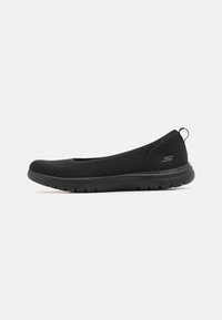 Schwarze Slipper mit flexibler Sohle, gefertigt aus texturiertem Stoff mit atmungsaktivem Design. Mit Polsterung für Komfort und einer Zugschlaufe hinten.