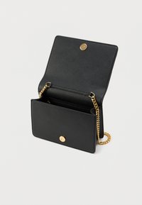 Μαύρο δερμάτινο τσάντα χειρός με υφή τελειώματος, εξαρτήματα σε χρυσό τόνο και λουράκι αλυσίδα. Διαθέτει κούμπωμα με πάτημα και εσωτερικά διαμερίσματα.