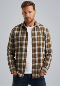 Karierte Flanellhemd in Braun-, Weiß- und Grautönen. Mit Knopfleiste und einem Logo-Patch auf der Brust. Leichte Stoffqualität.