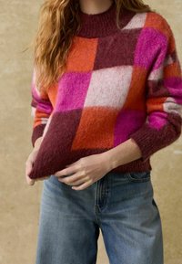 Strickpullover mit Rundhalsausschnitt, der ein großes Karomuster in Rosa, Orange, Burgunderrot und Weiß zeigt. Aus weicher, strukturiertem Wollmischung.