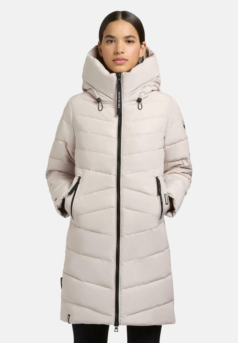 Lightweight, beige puffer coat with a high collar, zip closure, and side pockets. Chevron quilted pattern and adjustable hood.