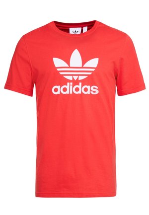 Rode katoenen T-shirt met een groot wit Adidas trefoil-logo en tekst, ronde hals, korte mouwen en zachte textuur.