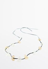 Náhrdelník s nepravidelně tvarovanými průhlednými a jantarovými kameny na černém šňůrce. Nastavitelná délka s minimalistickým designem.