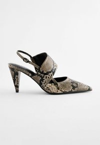 Escarpins à bout pointu avec bride arrière en imprimé serpent, présentant un design découpé, des tons noirs et beiges, et un talon aiguille élancé.