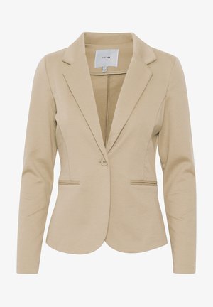Blazer ajusté beige pour femme avec revers crantés, fermeture à un bouton et deux poches avant passepoilées.
