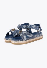 Sandali espadrilles in denim con design a fascia incrociata, tonalità di blu, accenti metallici e suola avvolta in iuta per una maggiore texture.