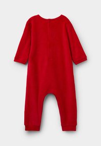 Combinaison rouge à manches longues en tissu doux, avec un col rond, une fermeture à boutons au dos et des poignets et chevilles élastiques.