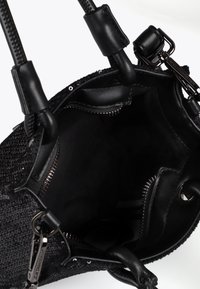 Sac à main noir ouvert avec deux poignées, montrant un intérieur doublé et des poches zippées. L'extérieur présente un design texturé tissé.