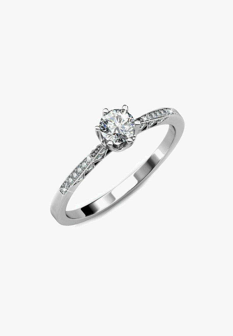 Anello di fidanzamento in oro bianco con un diamante centrale a brillante rotondo, con diamanti più piccoli incastonati lungo la fascia per un ulteriore scintillio.