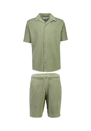 Jasnozielona koszula z krótkim rękawem z tkaniny frotte, zapinana na guziki, zestawiona z pasującymi szortami ze ściągaczem.