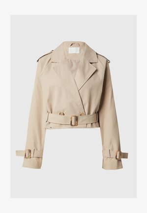 Beež mini trench-kood, millel on laiad kraed, kahekordne nööbi esikülg ja vöödiga talje. Kavandatud reguleeritavate mansettide ja minimaalsete riistade detailidega.