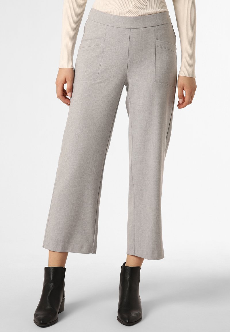 Helle graue weite Hosen mit glatter Textur, ausgestattet mit zwei Fronttaschen und einem flachen Bund, kombiniert mit schwarzen Stiefeletten.