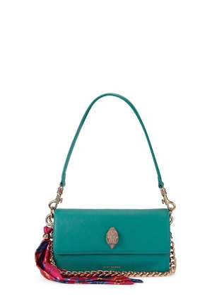 Borsa a mano in pelle verde acqua con catena e chiusura dorate, con una sciarpa rosa e blu fantasia annodata di lato.