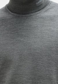 Grau gestrickter Rollkragenpullover aus Strickstoff. Verfügt über einen gerippten Kragen und ein dezentes Hugo-Logo. Weiche Textur mit tailliertem Design.