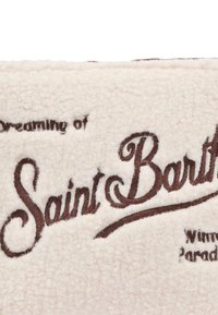 Coperta in pile, color crema con scritte ricamate marroni che recitano "Sognando Saint Barth", comprende dettagli e accenti scritti.