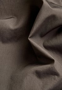 Ciemnobrązowa tkanina o gładkiej fakturze, wykazująca subtelny połysk i fałdy, które nadają materiałowi głębię i wymiar.