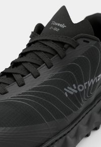 Chaussure de course noire avec un dessus en mesh texturé, des lignes d'accent grises et une semelle rembourrée. Les lacets sont étroitement tressés pour un ajustement sécurisé.