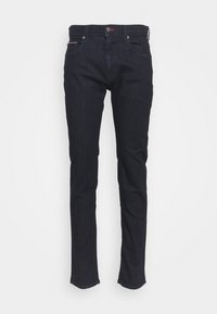 Σκούρο μπλε τζιν με slim fit, μπροστινές τσέπες, κλείσιμο με κουμπί και διακριτική κόκκινη ραφή στη ζώνη και στις τσέπες.