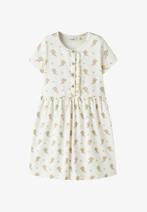 Robe blanche à manches courtes avec petit imprimé floral jaune, encolure ronde, quatre boutons en bois sur le devant et un volant le long de la ligne de boutons.