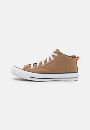 Zapatilla alta de lona marrón con cordones blancos, puntera de goma y suela a rayas en blanco y negro. Presenta un detalle en naranja en el talón.