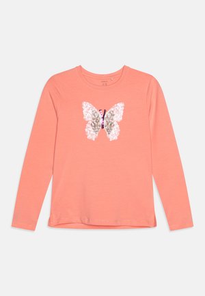 Cămașă lungă cu mâneci de culoare coral, prezentând un design cu fluturi realizat din paiete, cu un guler rotund și un tiv ușor curbat.