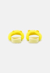 Yellow fuzzy slide sandals with a soft upper, plush texture, and rounded accents at the back. Lightweight rubber soles for comfort.