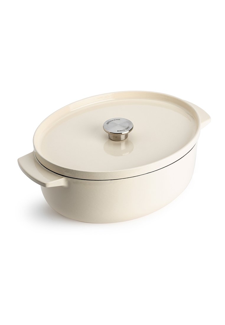 Owalna ceramiczna forma do zapiekania w kolorze kremowym o gładkiej powierzchni. Posiada stalowy przycisk na pokrywce oraz czarną dekoracyjną linię wokół krawędzi.