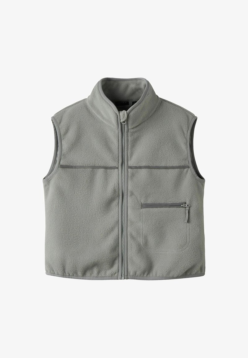 Pilkas vilnos liemenė su aukštu apykakle, pilnu priekiniu užtrauktuku, dviem horizontaliais krūtinės siūlėmis ir užtrauktuku užsegama kišene kairėje pusėje.