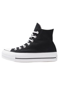 Czarne sneakersy typu high-top z płócienną cholewką, białymi sznurówkami, gumową podeszwą i noskiem; mają kontrastujący biały pasek wzdłuż podeszwy.