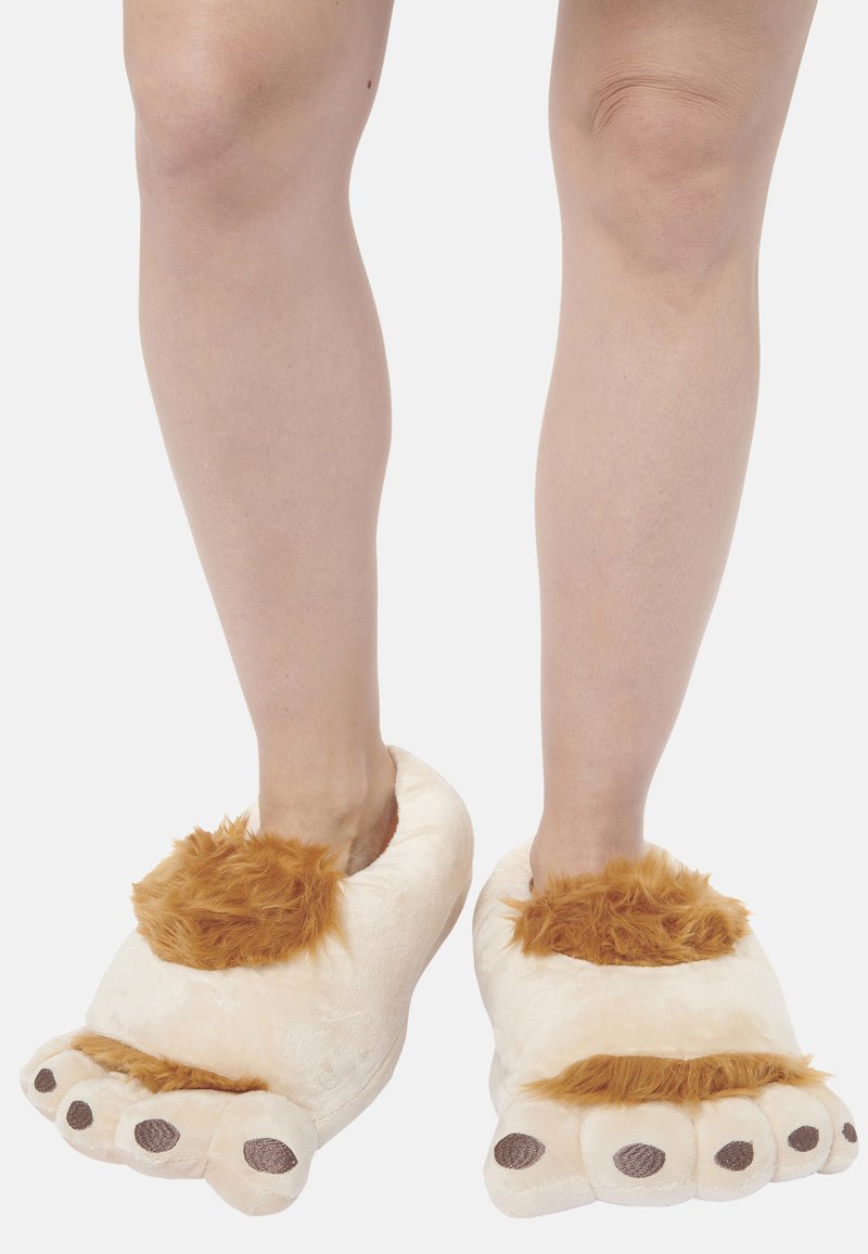 Plush lion-themed slippers feature a cream color, brown fur accents, and detailed paw design with soft, rounded toes and dark spots.