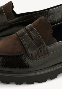 Braune Lederloafers mit strukturierter Oberfläche und einem kontrastierenden Wildleder-Oberteil, dekorativem Riemen und dicker Gummisohle.