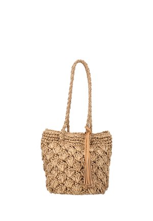 Tkany beżowy słomiany worek typu tote z plecionymi uchwytami i skórzaną frędzlą wiszącą z boku, na białym tle.