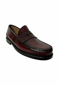 Leather loafer in deep burgundy with flat sole, stitched detailing, and decorative strap across the vamp. Smooth texture, rounded toe.