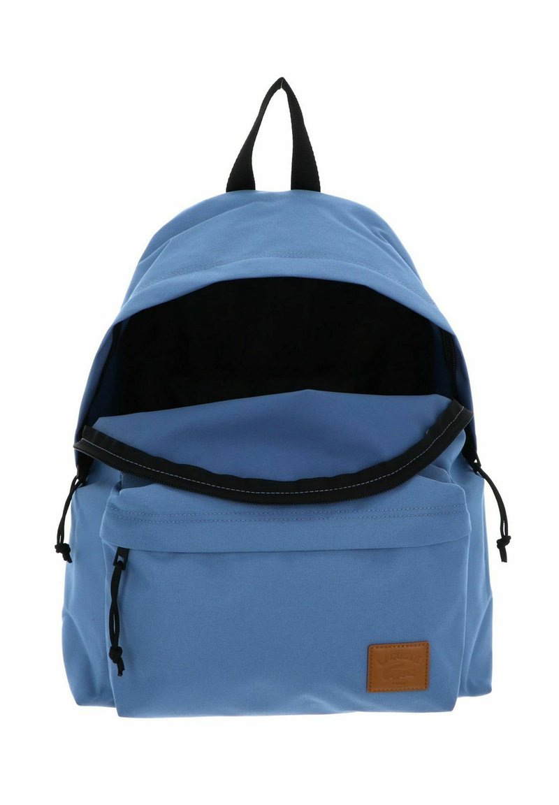 Hellblauer Rucksack mit schwarzen Reißverschlusslaschen, offenem Hauptfach, Frontreißverschlusstasche und einem braunen rechteckigen Logoaufnäher.